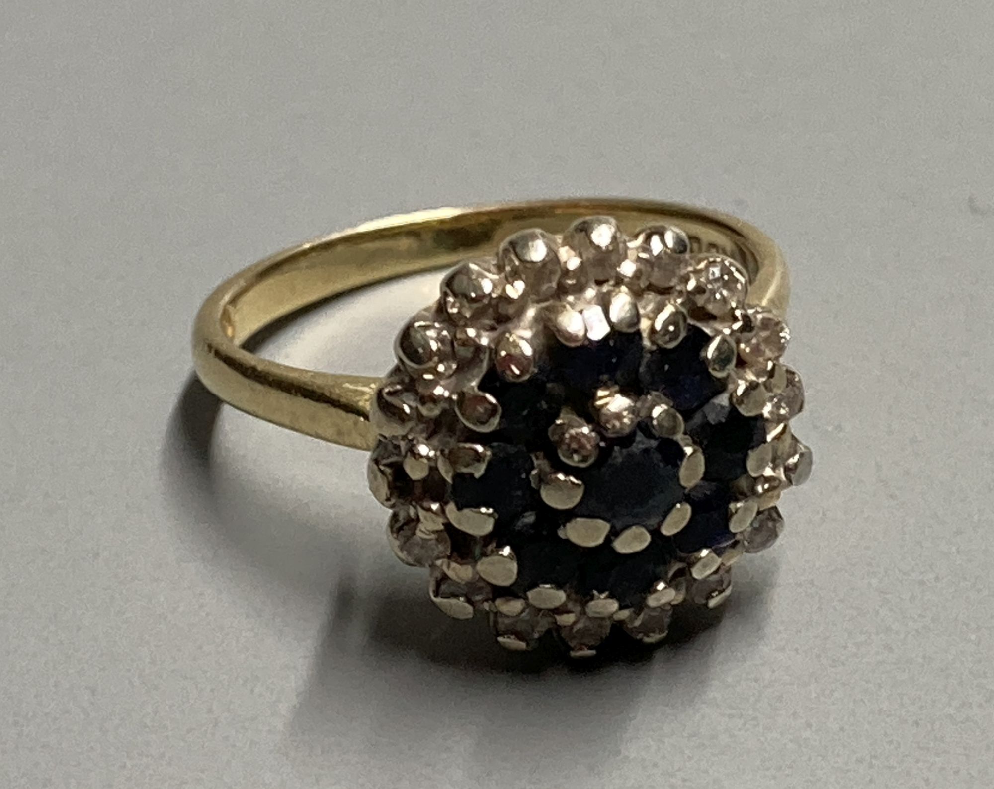 A modern 18ct gold, sapphire and diamond cluster dress ring, size K, gross 5.2 grams.